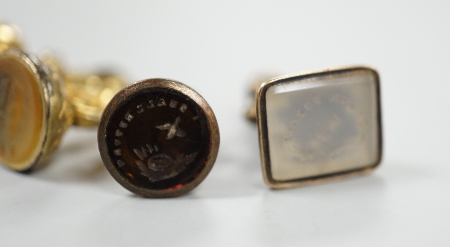 A 19th century yellow metal overlaid and amethyst set fob seal, the matrix carved with a phoenix, 20mm, together with four 19th century gold plated and chalcedony or citrine set fob seals.